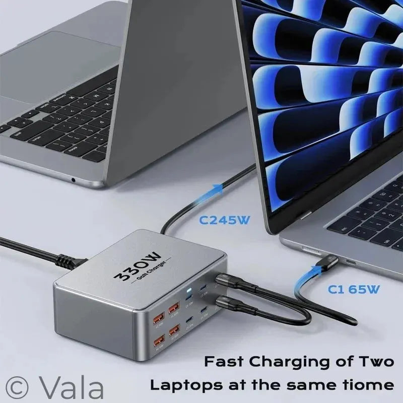 Laptop charger with multiple ports connected to two laptops on a light surface.