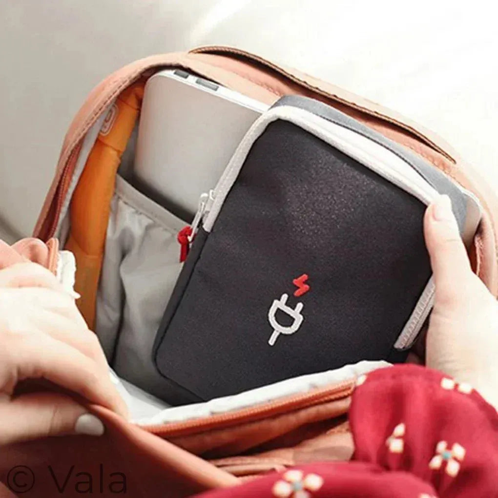 Person holding a black laptop case with a logo inside an open bag.