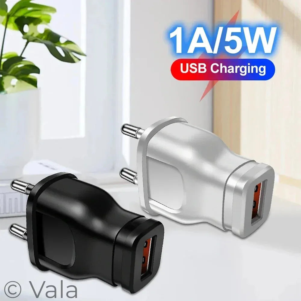 Two USB wall chargers shown on a light indoor surface: one black and one silver, with a blue and red '1A/5W USB Charging' graphic overlay in the top right.