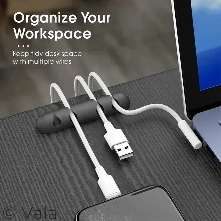 Desk organizer with multiple cables on a desk next to a computer screen.